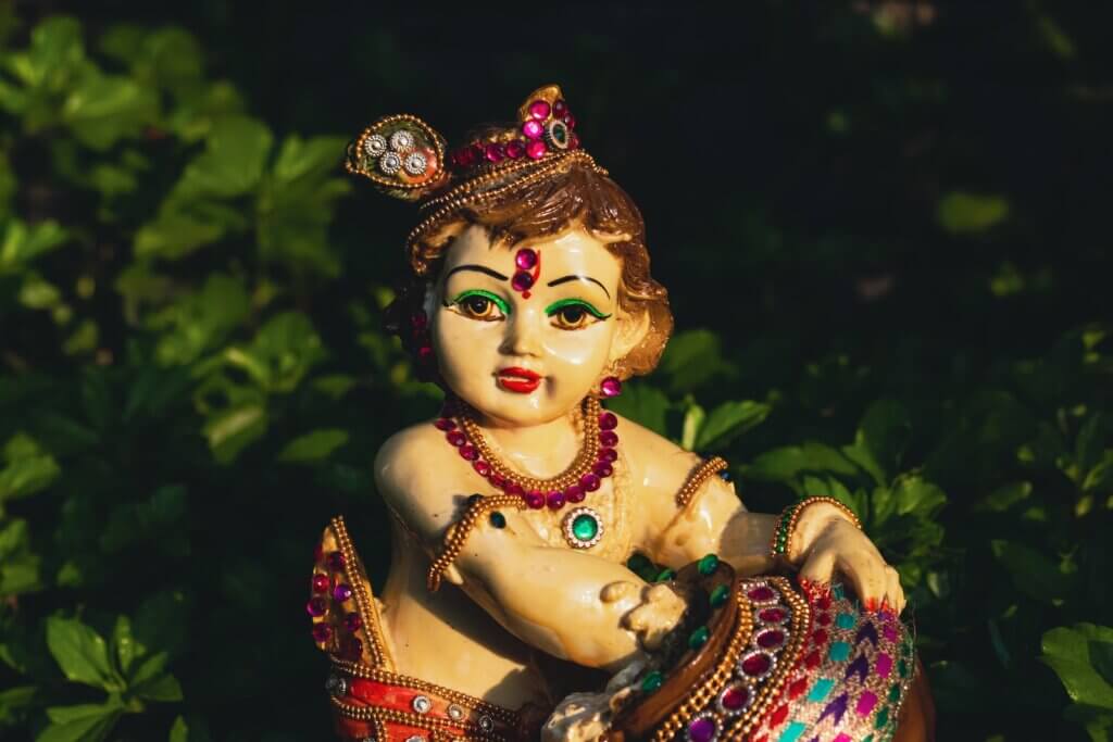 a statue of a woman sitting on top of a lush green field