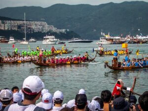 people watching dragon boat competition during daytime